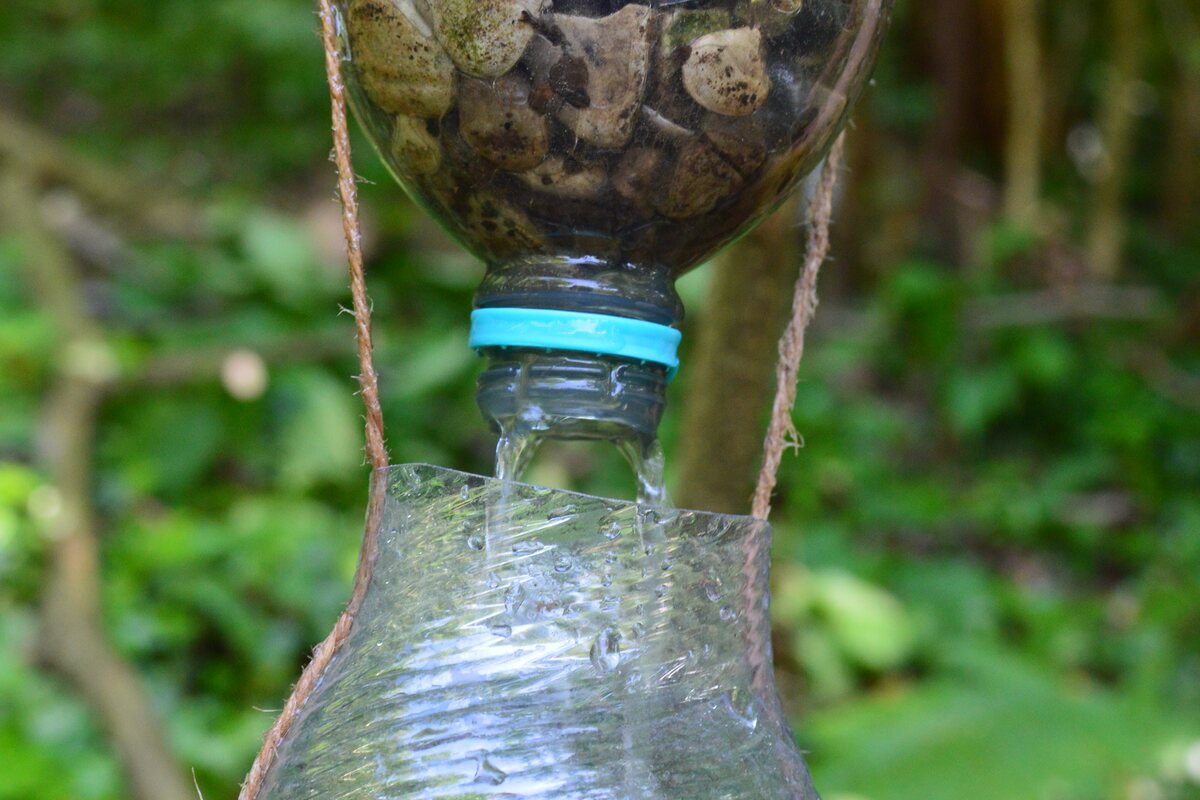 Ein selbst gebauter Wasserfilter aus zwei Flaschen im Wald